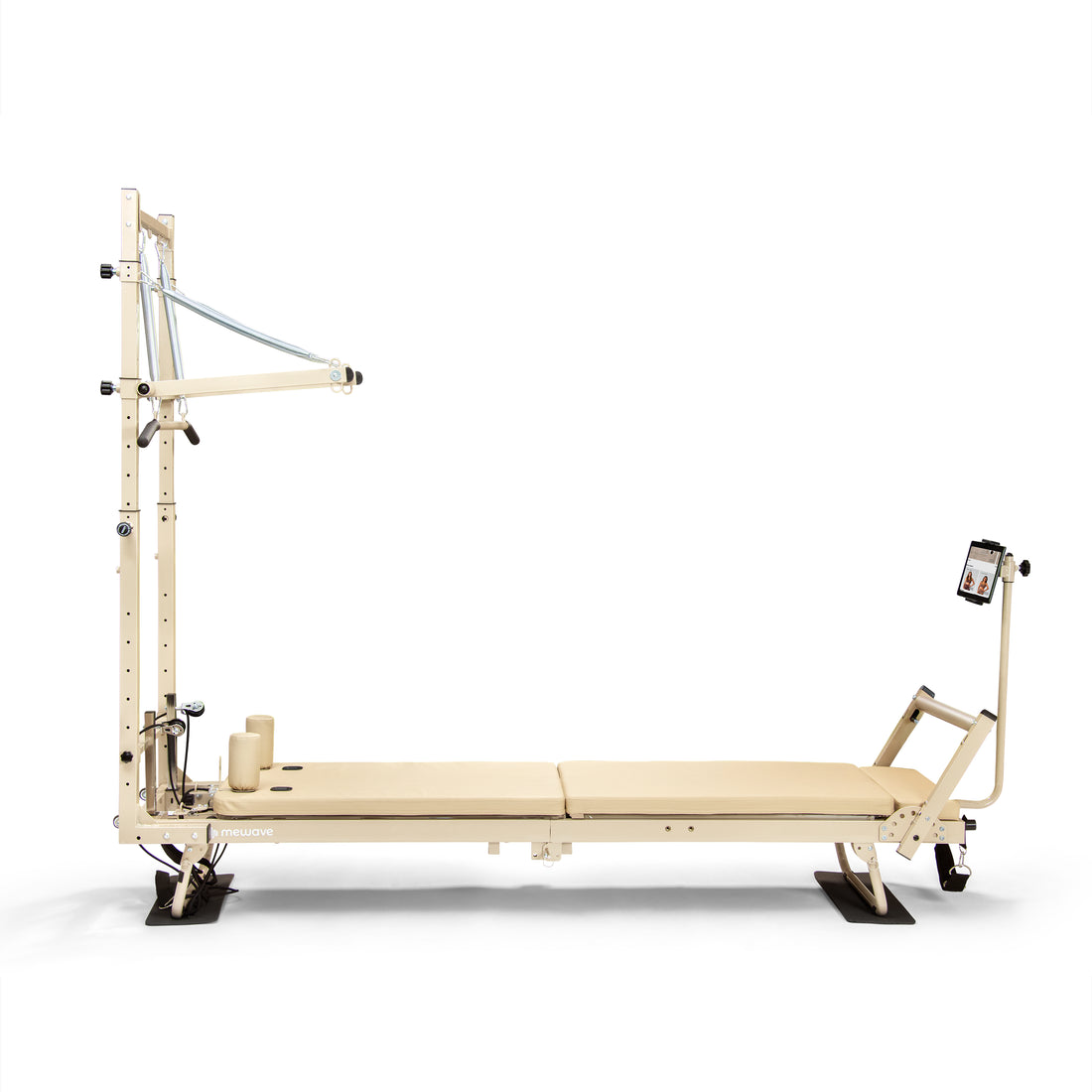Una máquina reformer de pilates beige con torre vertical y soporte para tableta sobre fondo blanco.