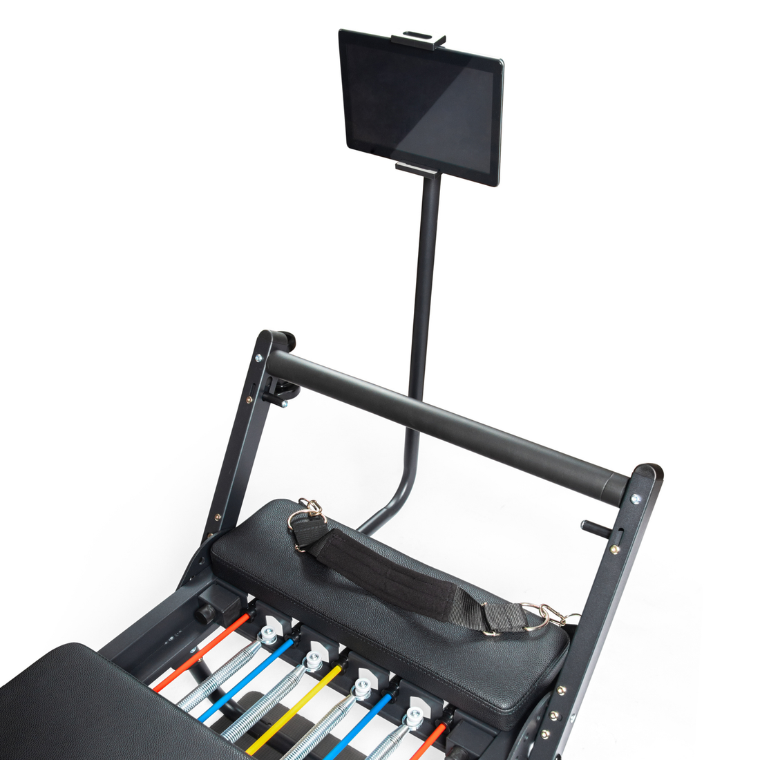 Una máquina de pilates reformer negra con resortes coloridos y soporte para tableta sobre fondo blanco.