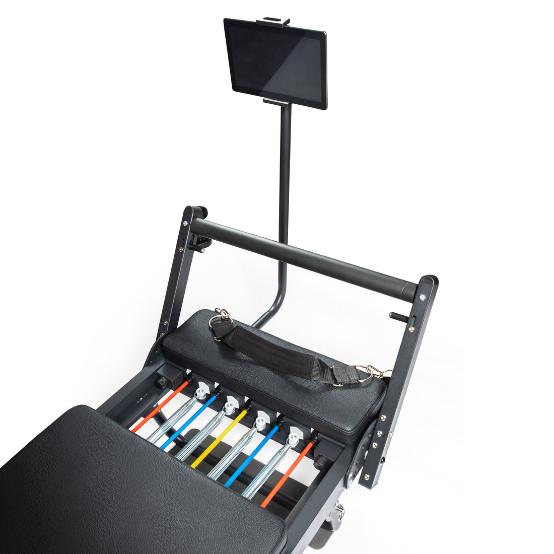 Máquina reformer de pilates negra con muelles coloridos y soporte para tableta sobre fondo blanco.