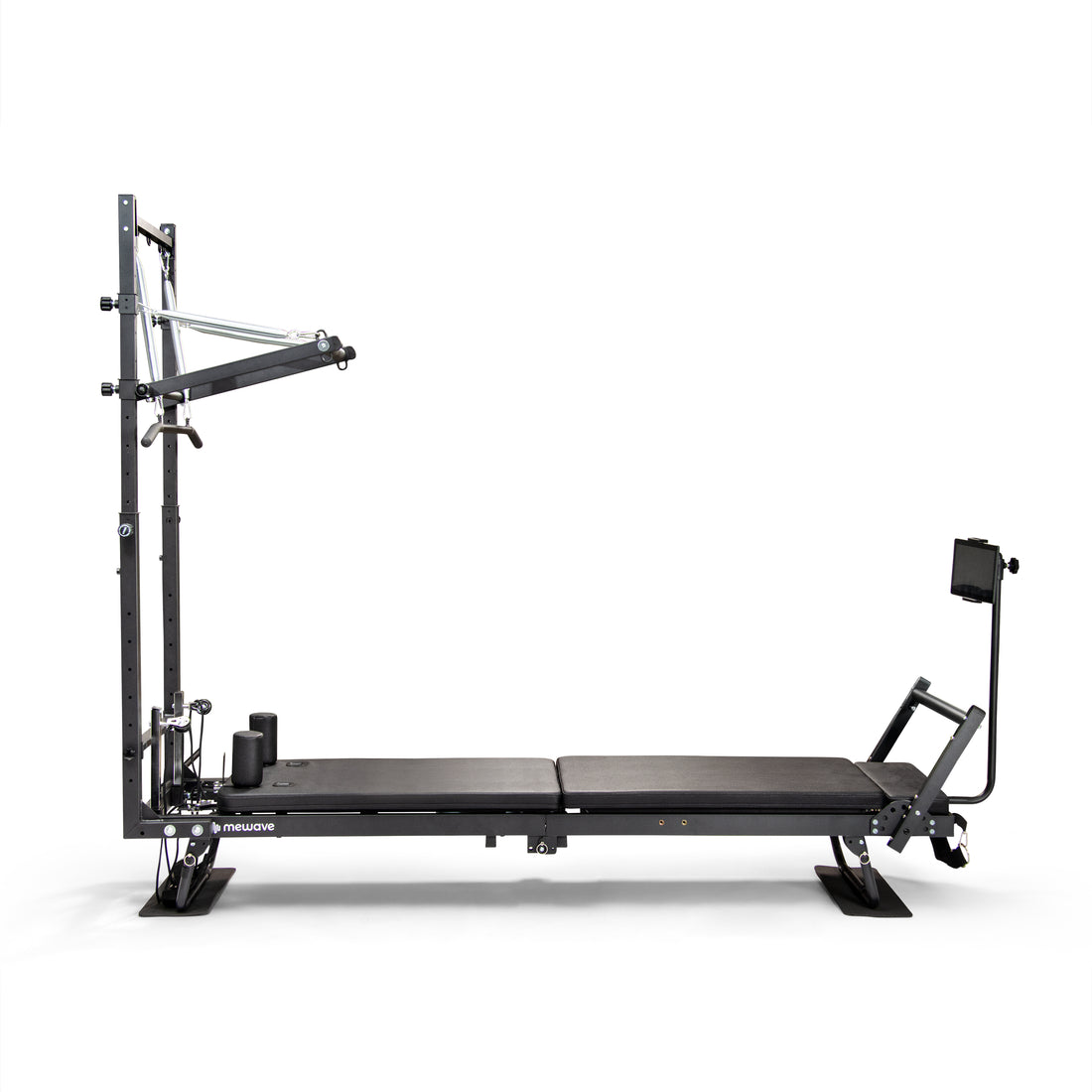 Una máquina reformer de pilates negra con un marco vertical y soporte para tableta sobre fondo blanco.
