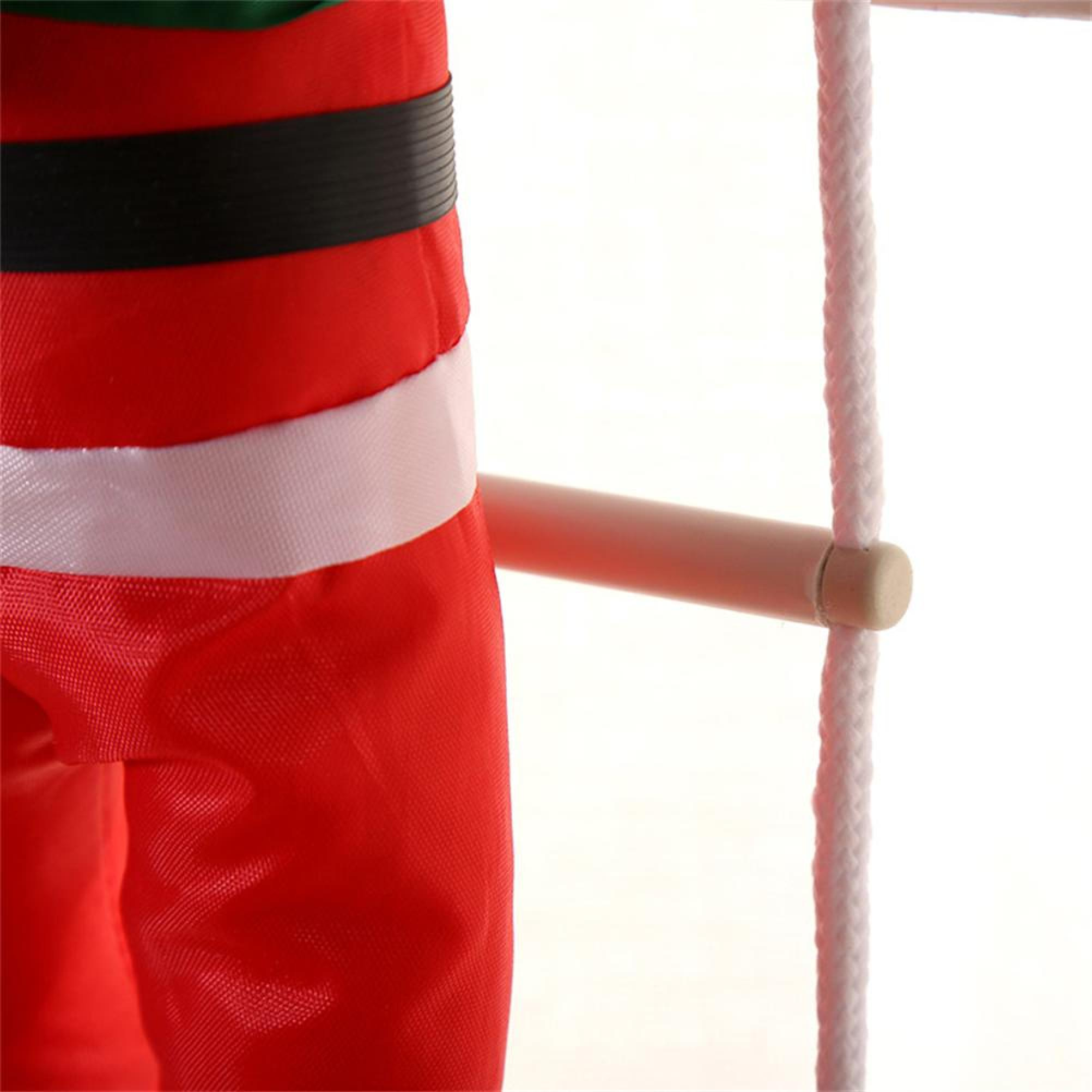 Eine Nahaufnahme einer Figur im Weihnachtsmann-Kostüm, die an einer weißen Strickleiter auf weißem Hintergrund klettert.