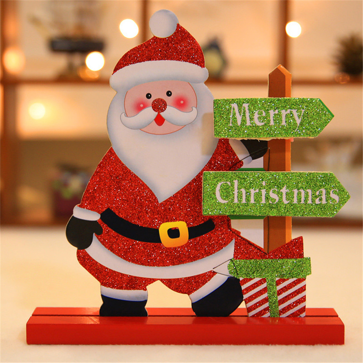 Glitzernde Weihnachtsmann-Figur mit Schildern mit der Aufschrift 'Merry Christmas' und einem Geschenk.