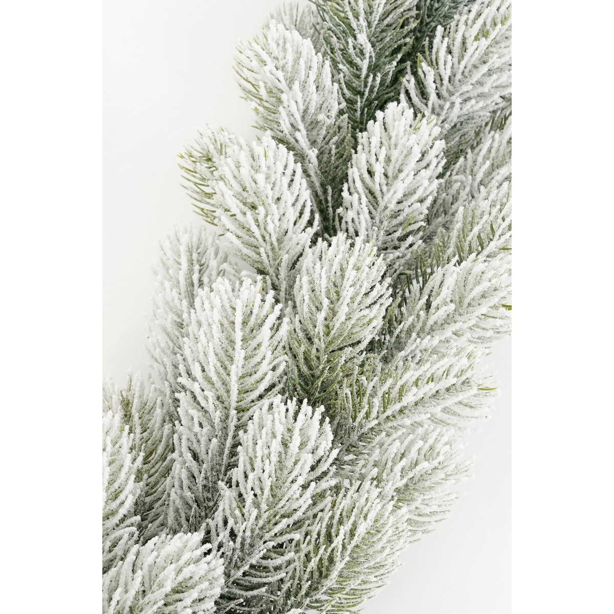 Kunstmatige dennenlinger met witte sneeuw op groene naalden.