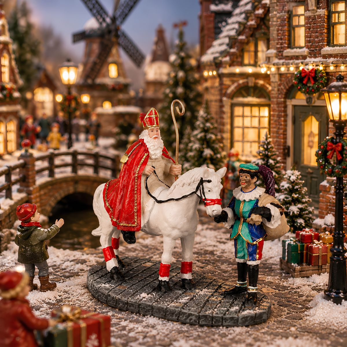 Miniatur-Sinterklaas auf einem Schimmel mit Helfer, Kind und Geschenken in einem verschneiten Weihnachtsdorf.
