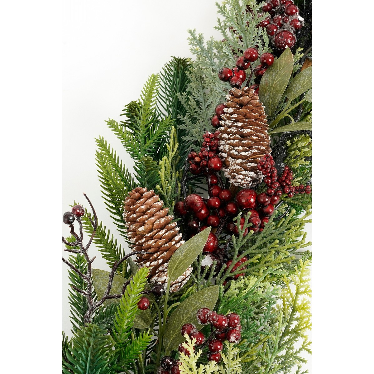 Kerstslinger met dennenappels, rode bessen en groen loof.
