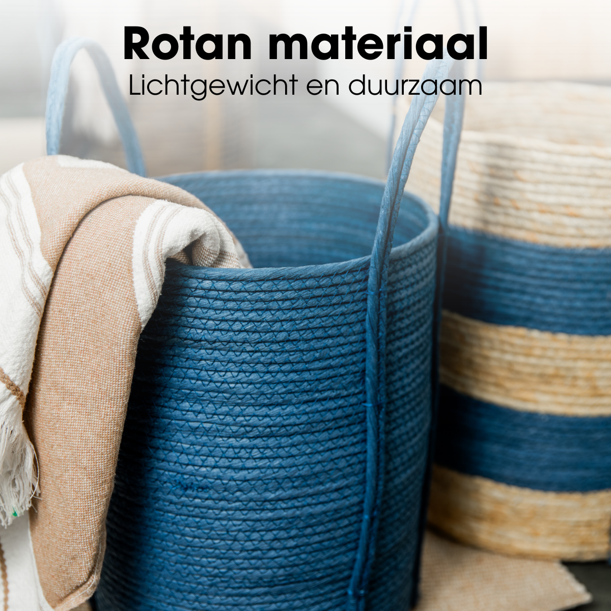 Panier à linge tissé bleu avec poignées et serviette, et un autre panier rayé en arrière-plan.