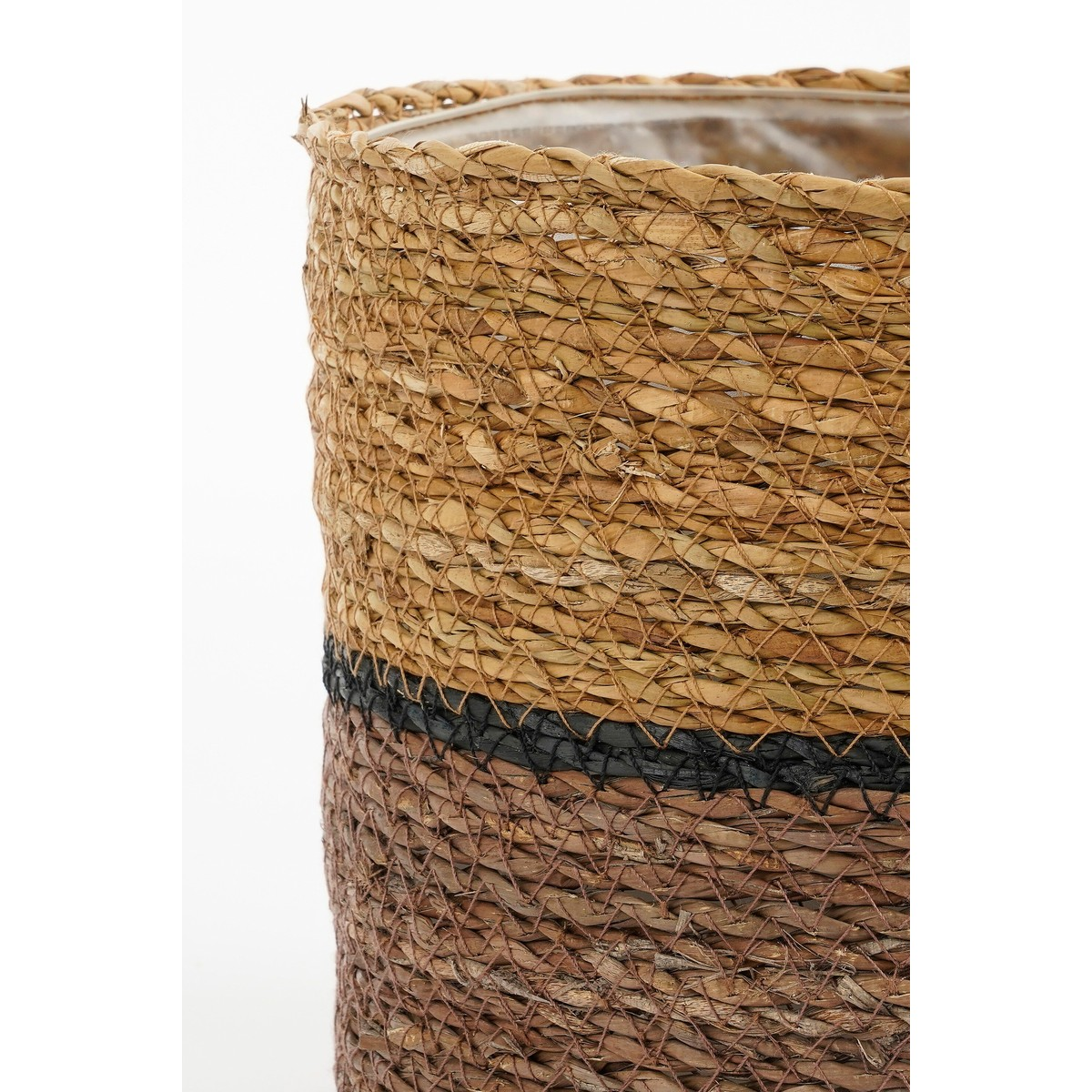 Un panier cylindrique en fibres naturelles avec des rayures marron, noires et beige sur fond blanc.