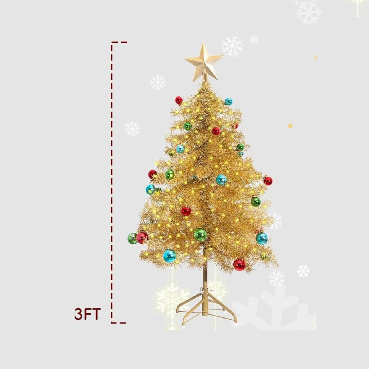 Ein 3 Fuß großer, goldener Weihnachtsbaum mit Lichtern, bunten Kugeln, einem Sternspitz und Schneeflocken im Hintergrund.