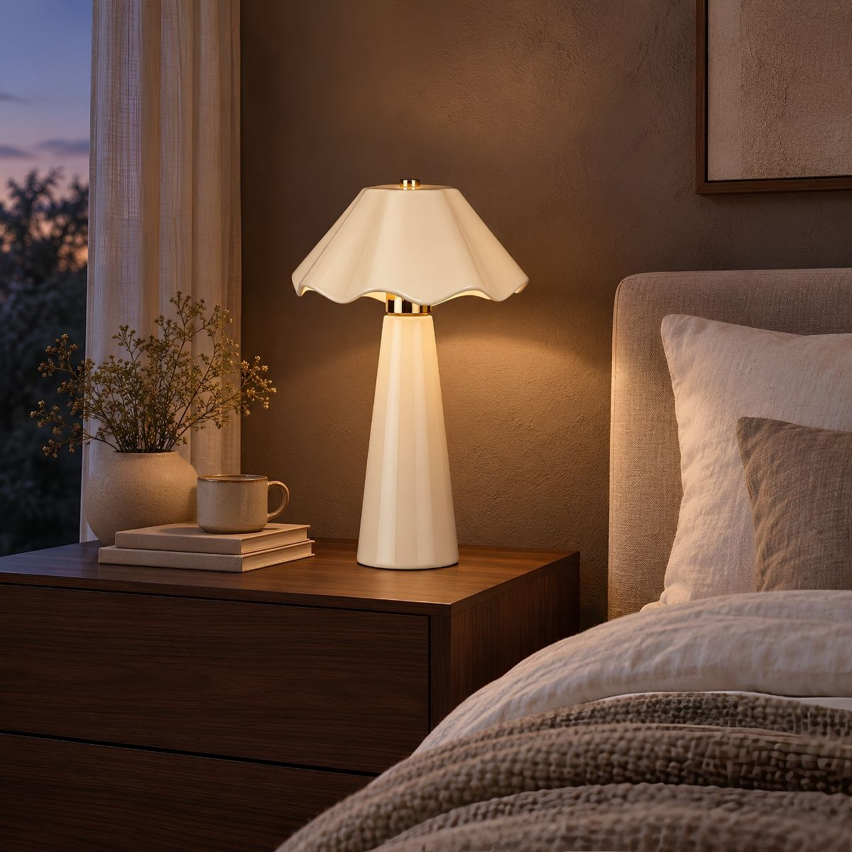Eine weiße Tischlampe auf einem Holznachttisch neben einem Bett, mit einer Vase und Tasse.