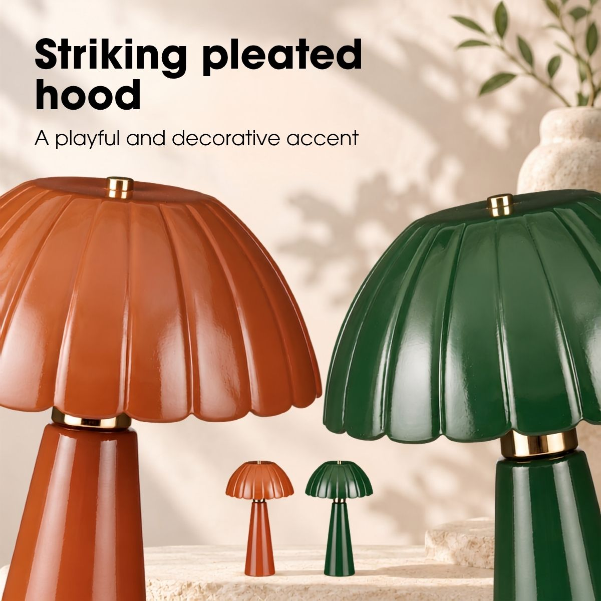Zwei dekorative Lampen mit plissierten Schirmen in Orange und Grün auf einem Tisch.