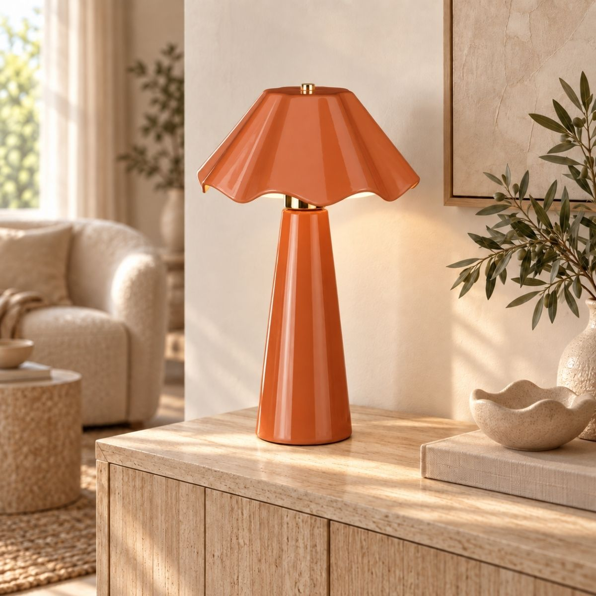 Eine orange glänzende Tischlampe steht auf einem Holzschrank, mit Deko und verschwommenem Wohnzimmer im Hintergrund.