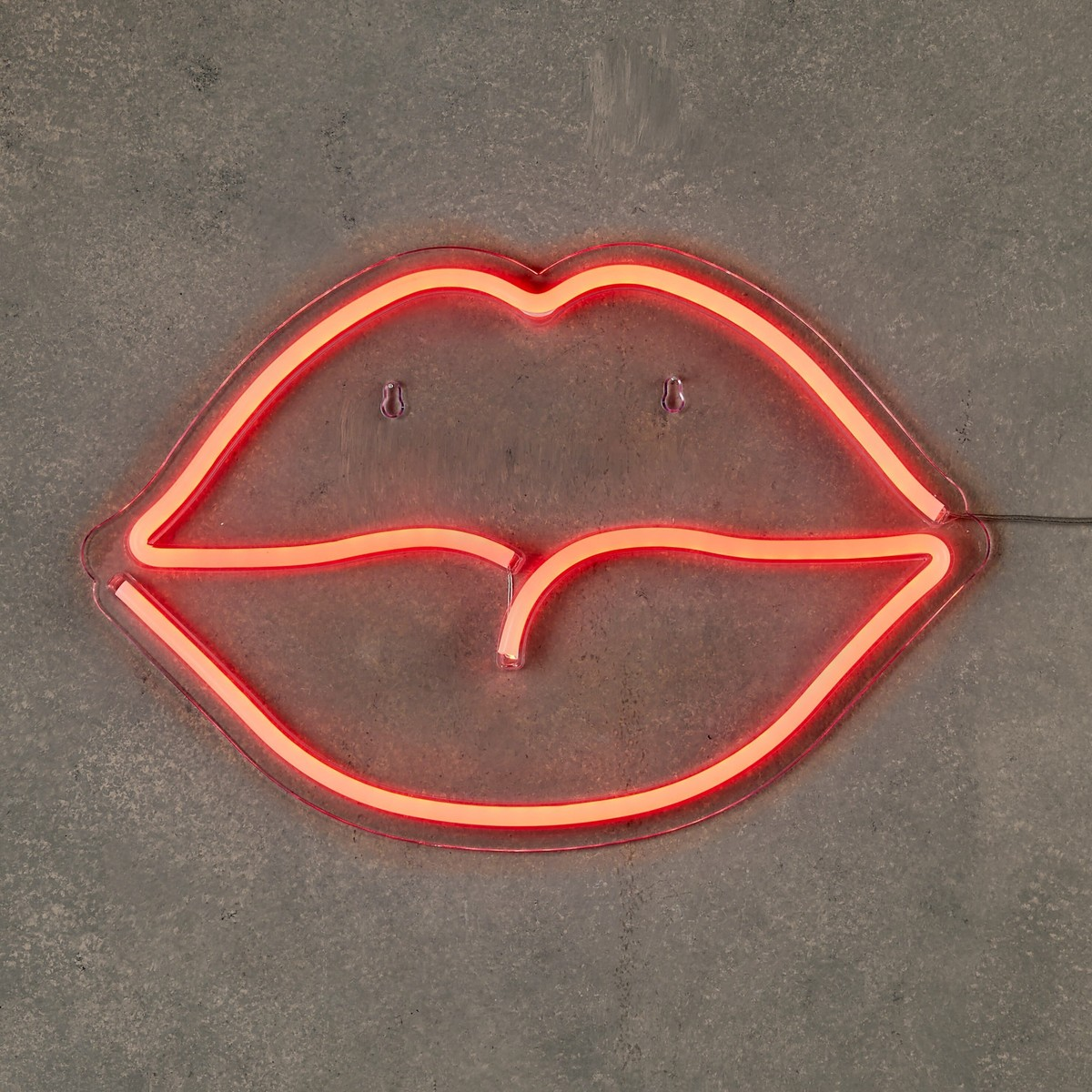 Ein rotes Neonlippen-Schild an einer grauen Betonwand.