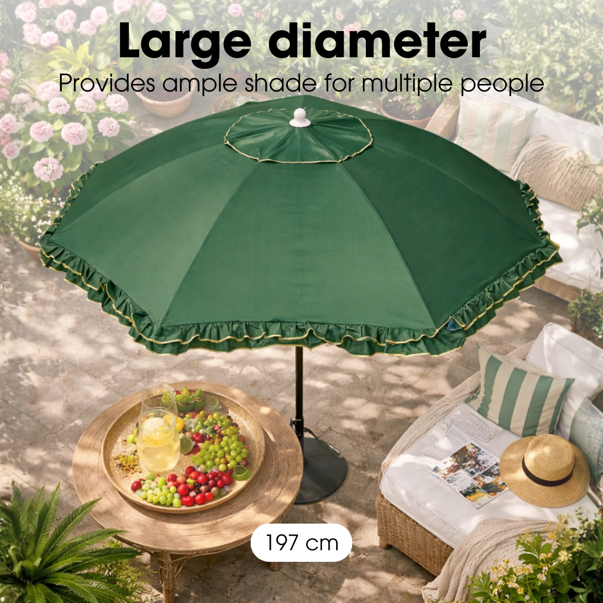 Großer grüner Gartenschirm über einem Tisch mit Früchten und Liegestühlen im Garten.