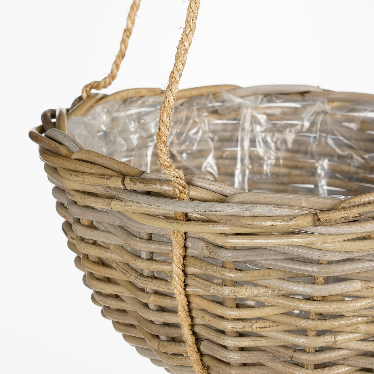 Ein hängender Rattankorb mit Plastikeinsatz und Juteseilen auf weißem Hintergrund.