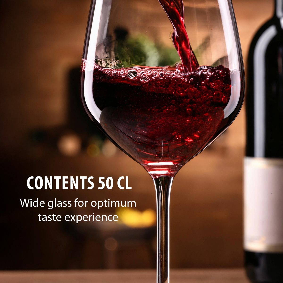 Rotwein wird in ein großes Glas gegossen, im Hintergrund steht eine Flasche.
