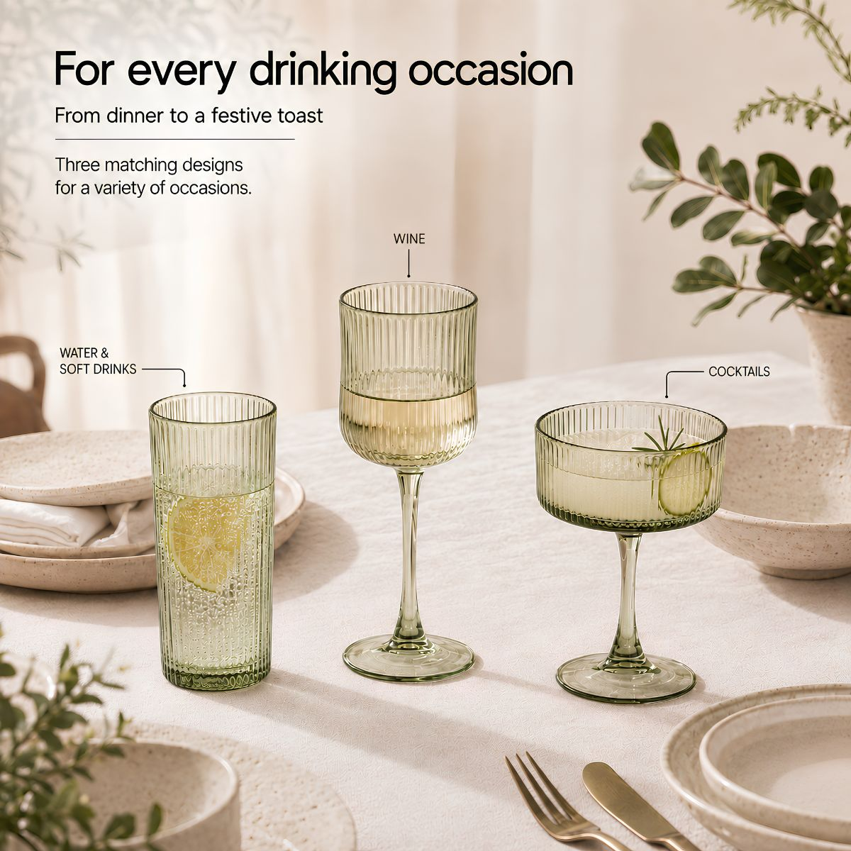 Drei grüne Rillengläser für Wasser, Wein und Cocktails auf einem gedeckten Tisch mit Pflanzen.