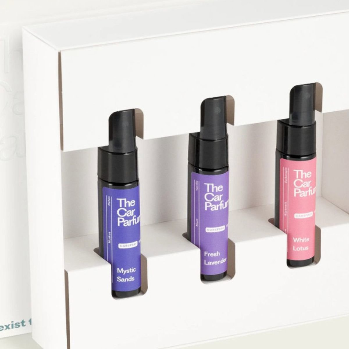 Drie autodeodorantflesjes in een witte doos.