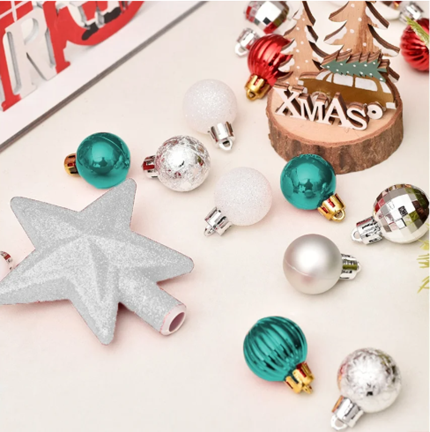 Weihnachtsdekorationen mit einem silbernen Stern, bunten Kugeln und einem hölzernen Weihnachtsschild.