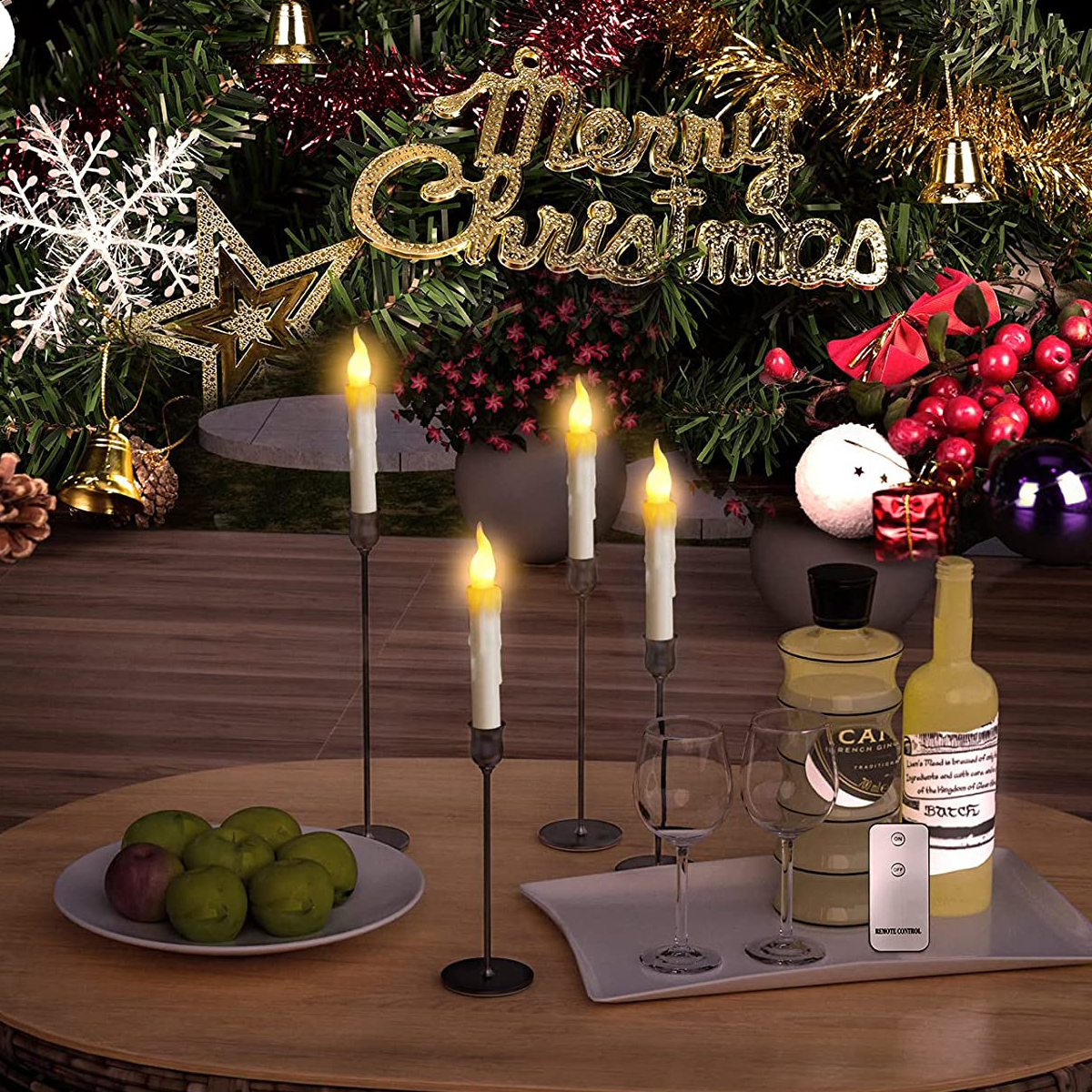 Weihnachtstisch mit Kerzen, Gläsern, Flaschen, einer Obstschale und festlichem Hintergrund.