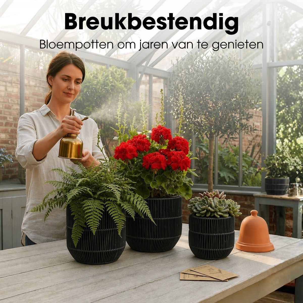 Une femme vaporise des plantes d'intérieur dans des pots noirs dans une serre.