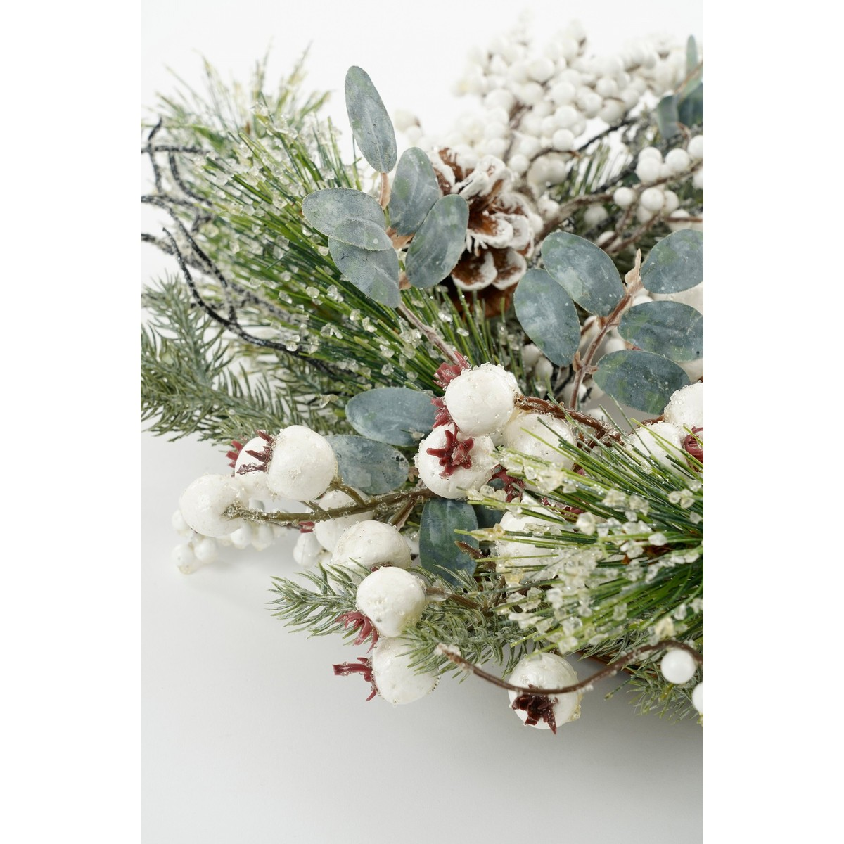 Festlicher Kranz aus Pinienzweigen, weißen Beeren, Eukalyptus und Zapfen.