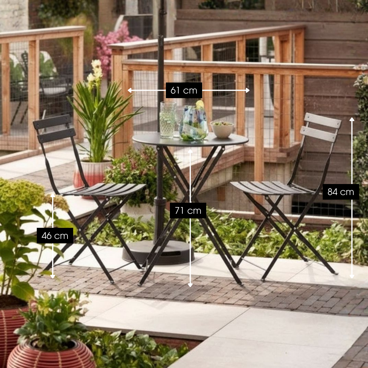 Ein schwarzes Bistro-Set aus Metall auf einer Terrasse mit Maßangaben in cm.