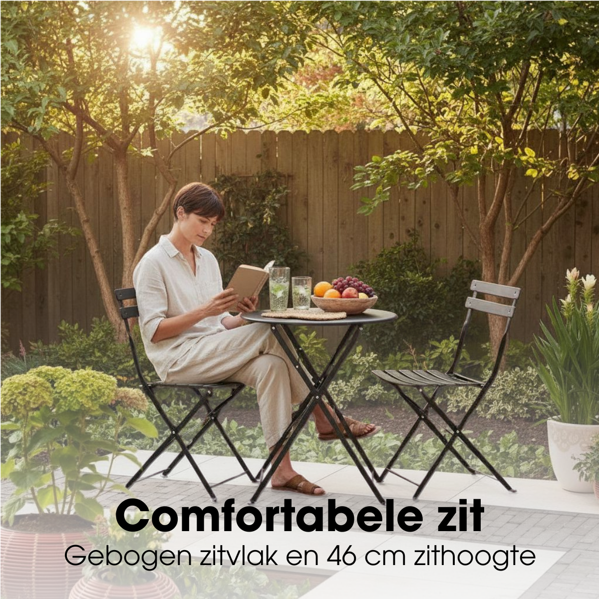 Eine Frau sitzt auf einem Stuhl im Garten, liest ein Buch am Tisch mit Obst und Gläsern.