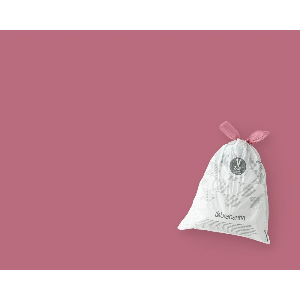 Ein weißer Brabantia Müllbeutel mit rosa Bändern vor einfarbig rosa Hintergrund.