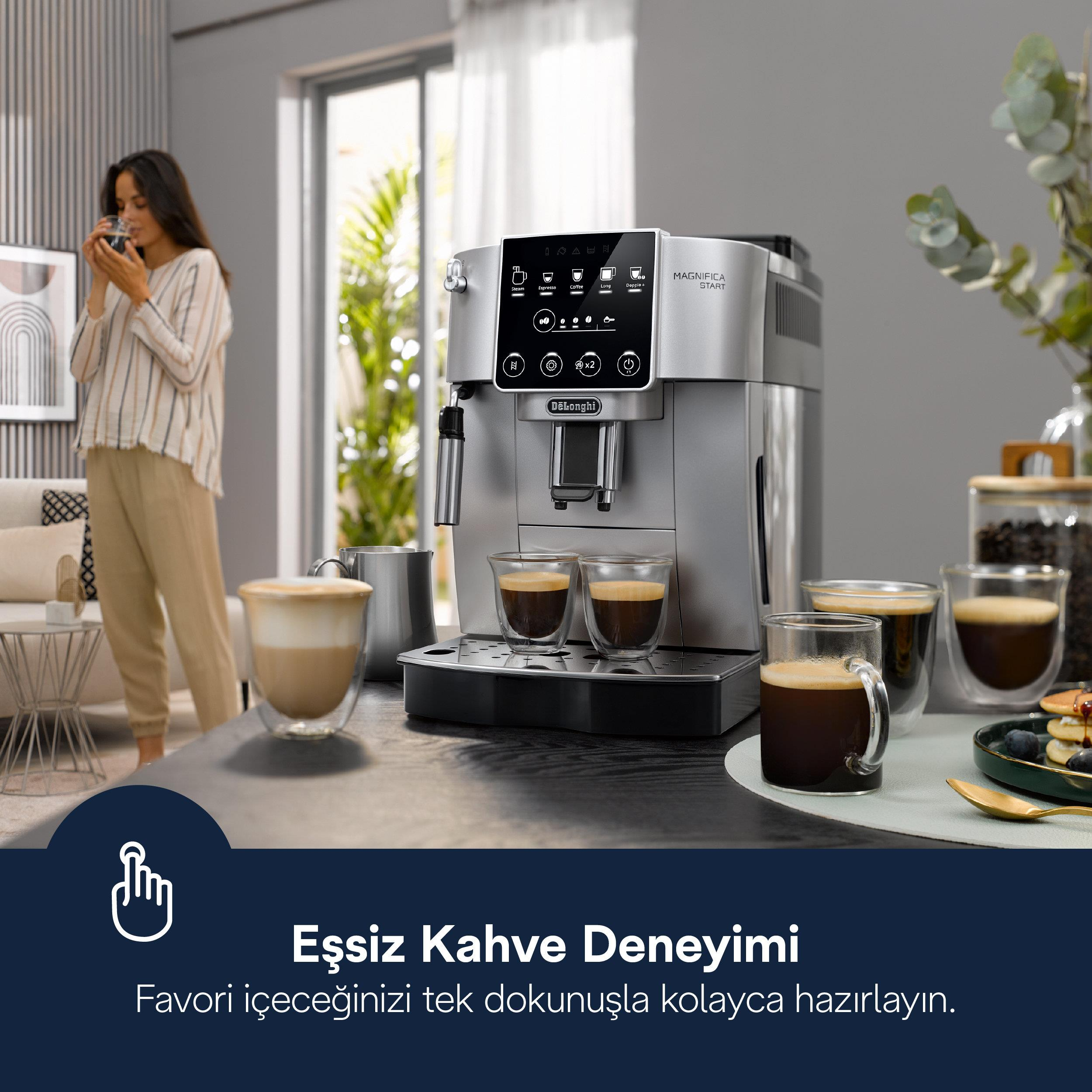 Masada kahve fincanlarıyla bir DeLonghi kahve makinesi, arkada kahve içen bir kadın.