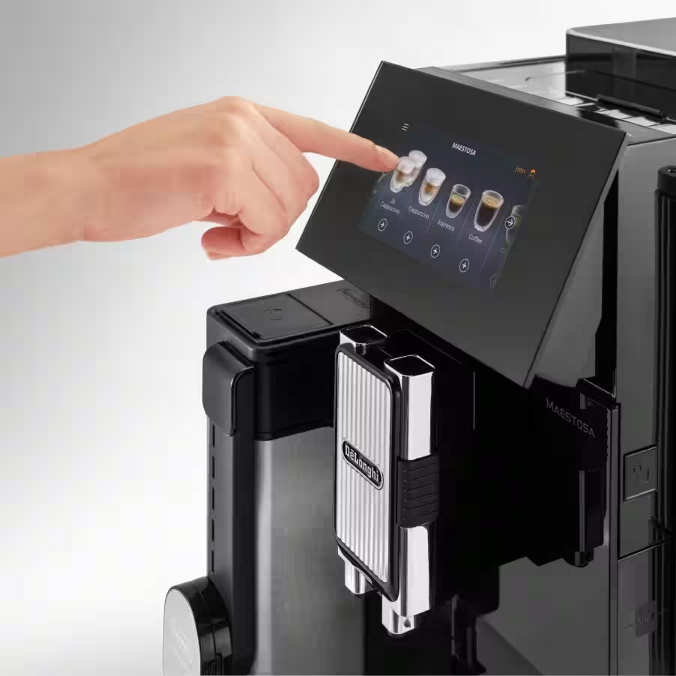 Eine Hand bedient den Touchscreen einer modernen schwarzen De'Longhi Maestosa Kaffeemaschine.