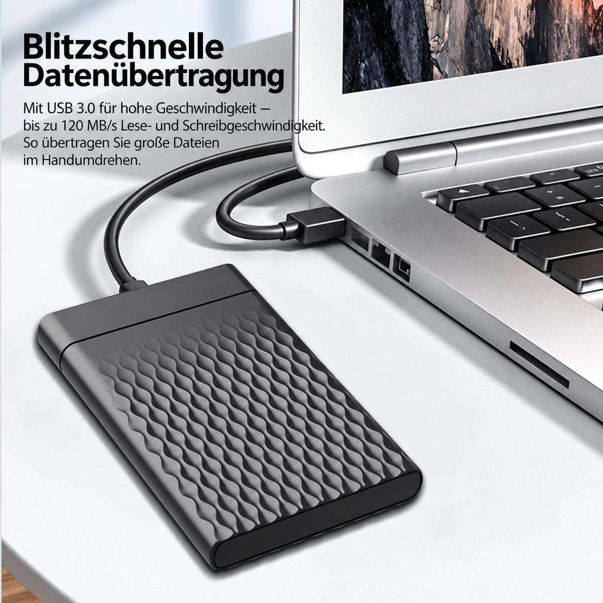Eine schwarze externe Festplatte ist per Kabel an einen silbernen Laptop angeschlossen.