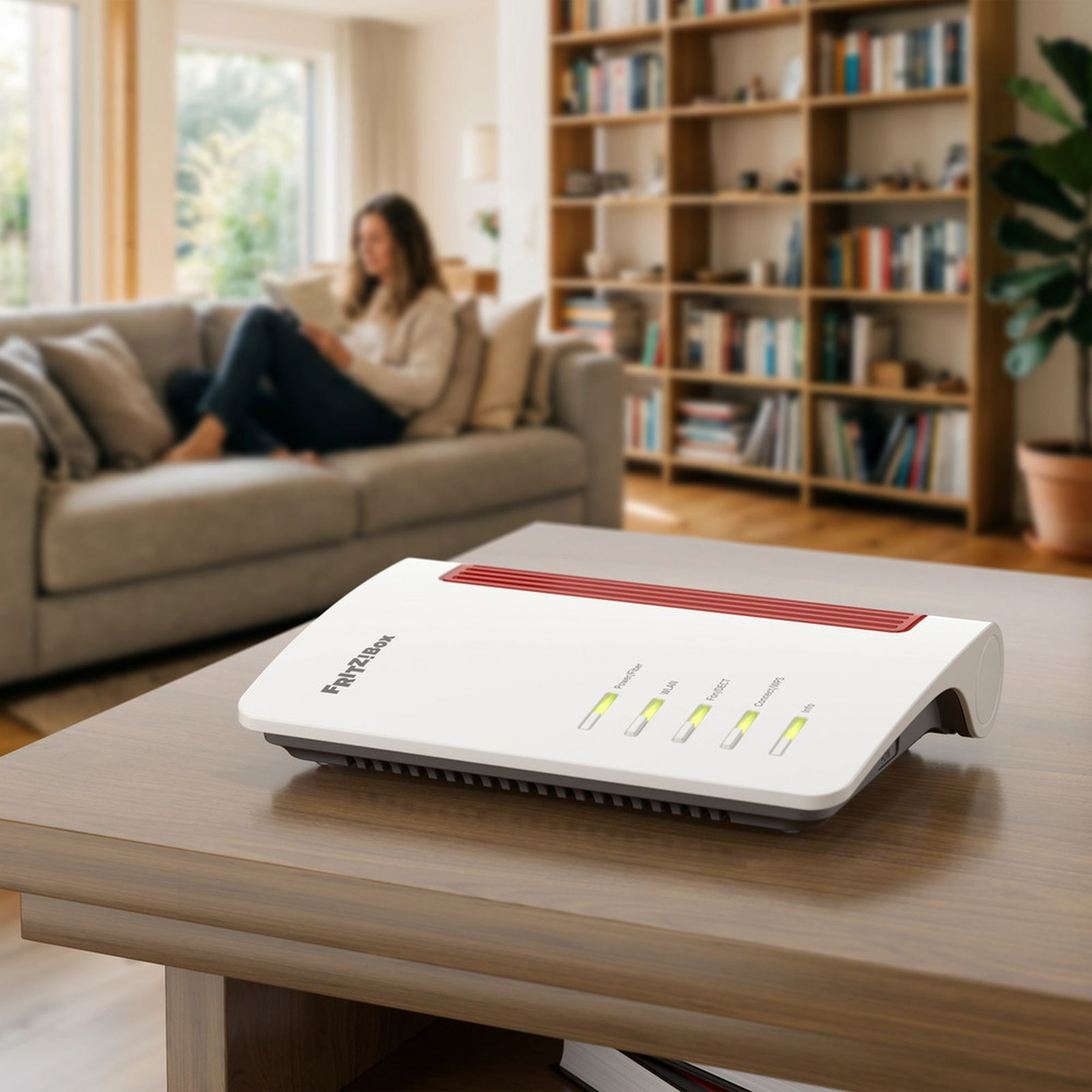 Ein weißer FRITZ!Box-Router steht auf einem Holztisch, im Hintergrund sitzt eine Frau auf einem Sofa in einer gemütlichen Wohnung.