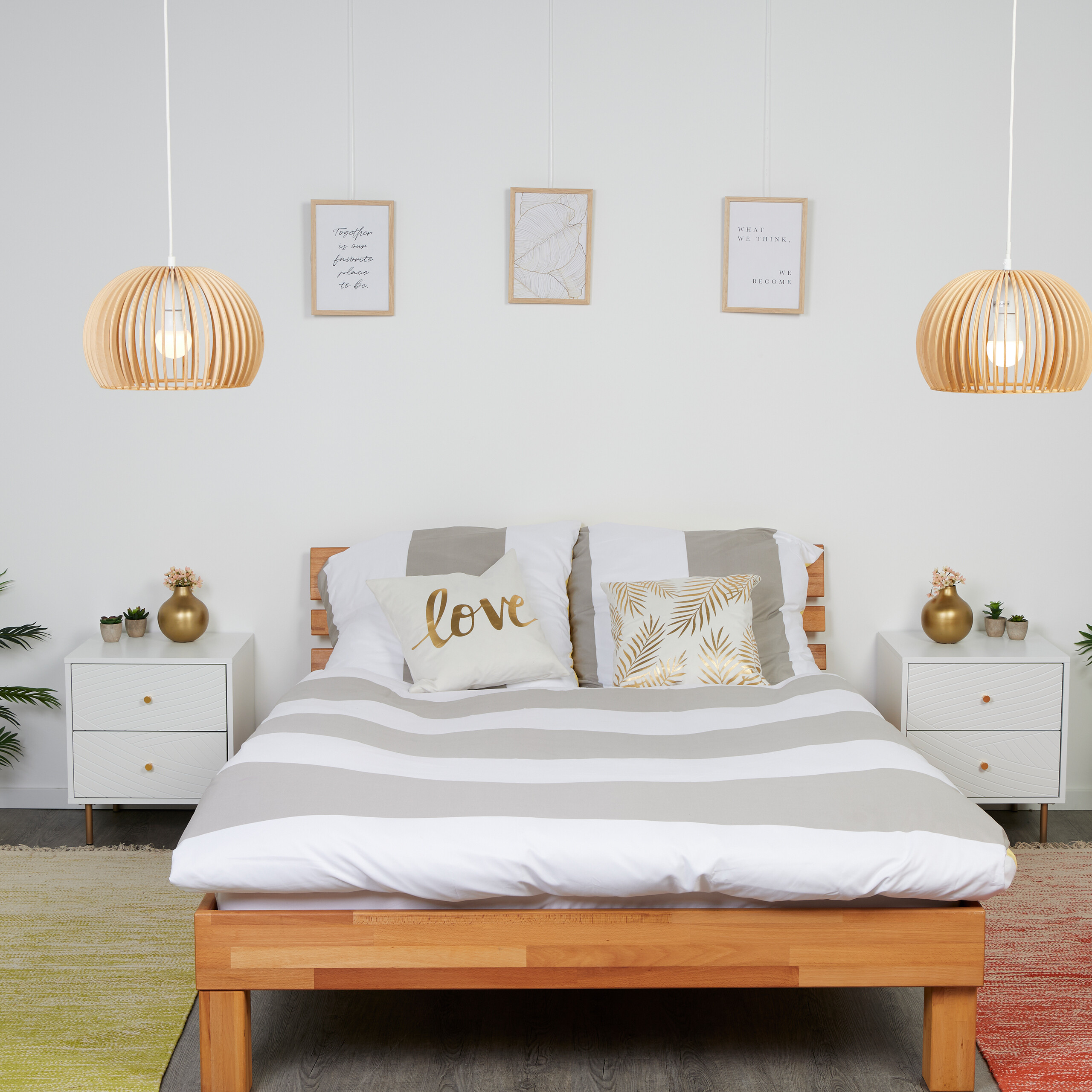 Gemütliches Schlafzimmer mit Holzbett, graubettwäsche, hängenden Lampen und Nachttischen mit Dekoration.