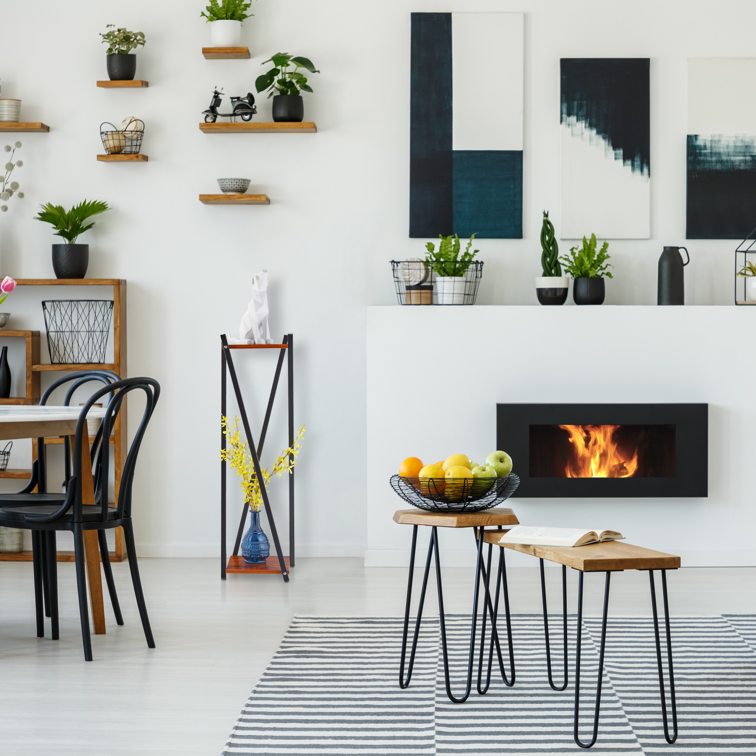 Modernes Wohnzimmer mit Kamin, Holztischen, Obstkorb und Pflanzen.