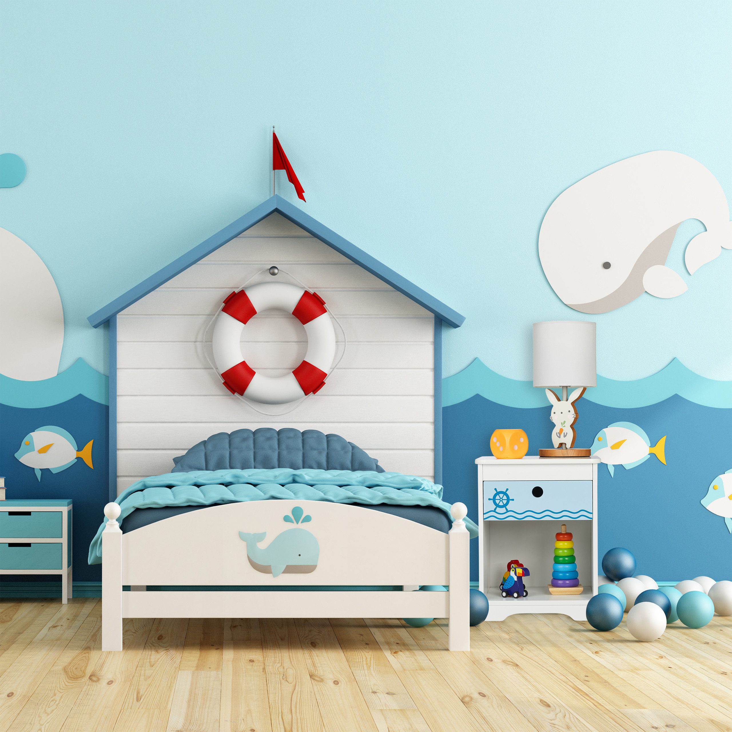 Kinderschlafzimmer mit maritimem Thema, Hausbett mit Rettungsring, Nachtschrank, Wal-Wanddeko und Bällen auf dem Boden.
