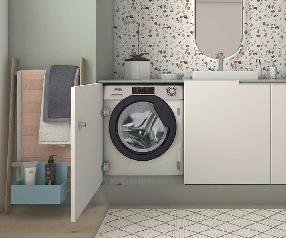 Una lavatrice è parzialmente nascosta in una moderna lavanderia con parete in terrazzo e lavandino bianco.