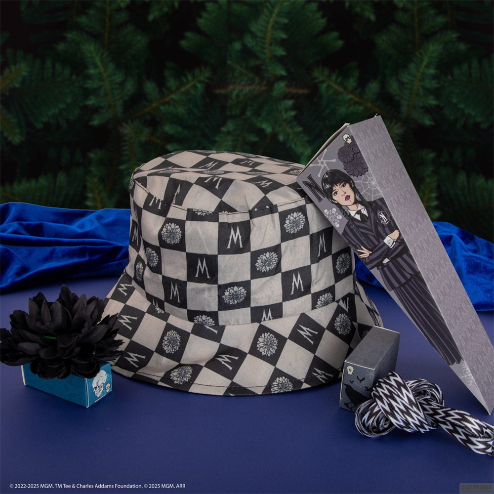 Un sombrero de pescador a cuadros blanco y negro con motivos de flores y letras, acompañado de una caja de regalo.