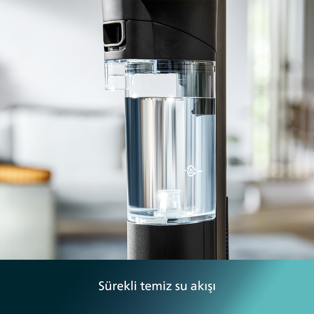 Bulanık bir arka plana sahip siyah cihaz üzerindeki şeffaf su deposunun yakın planı.