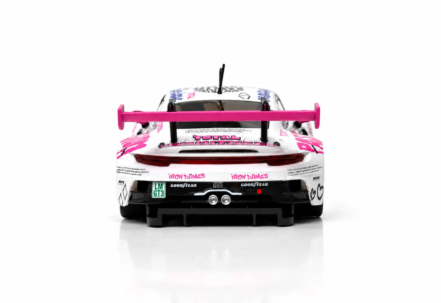 Vista trasera de un coche de carreras blanco con alerón rosa y pegatinas de patrocinadores sobre fondo blanco.