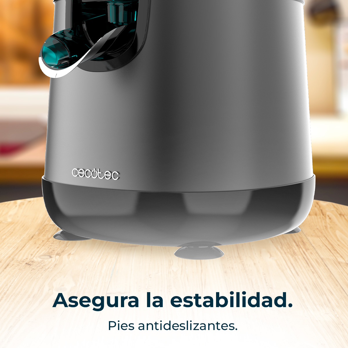 Exprimidor Cecotec gris con pies de ventosa antideslizantes sobre mesa de madera.