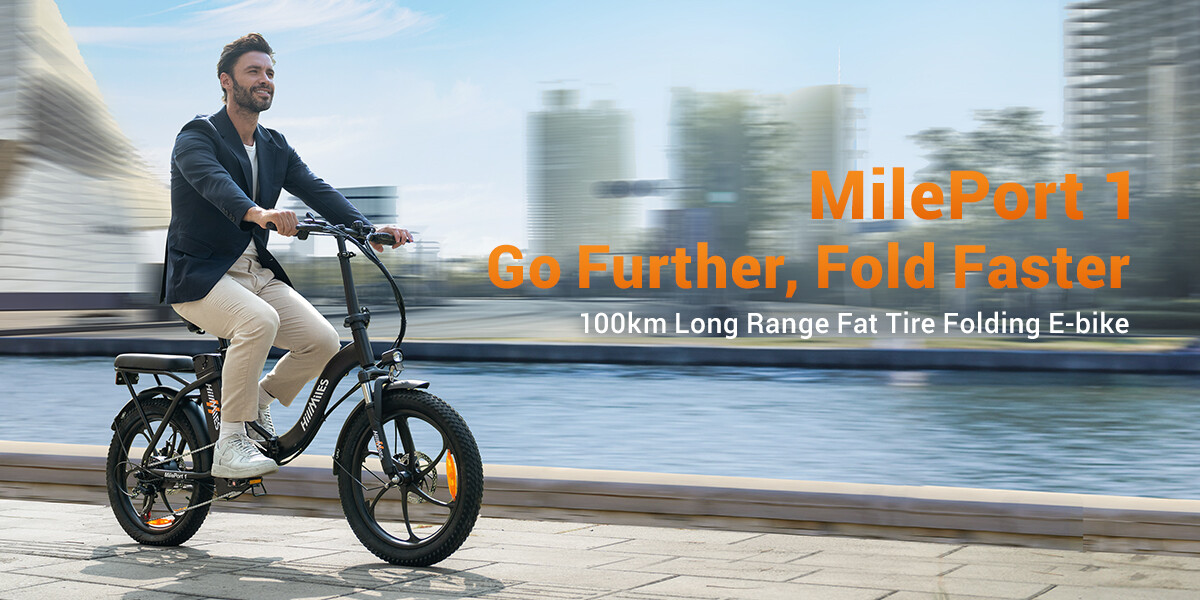 Ein Mann fährt ein schwarzes MilePort 1 E-Bike an einer Uferpromenade vorbei.