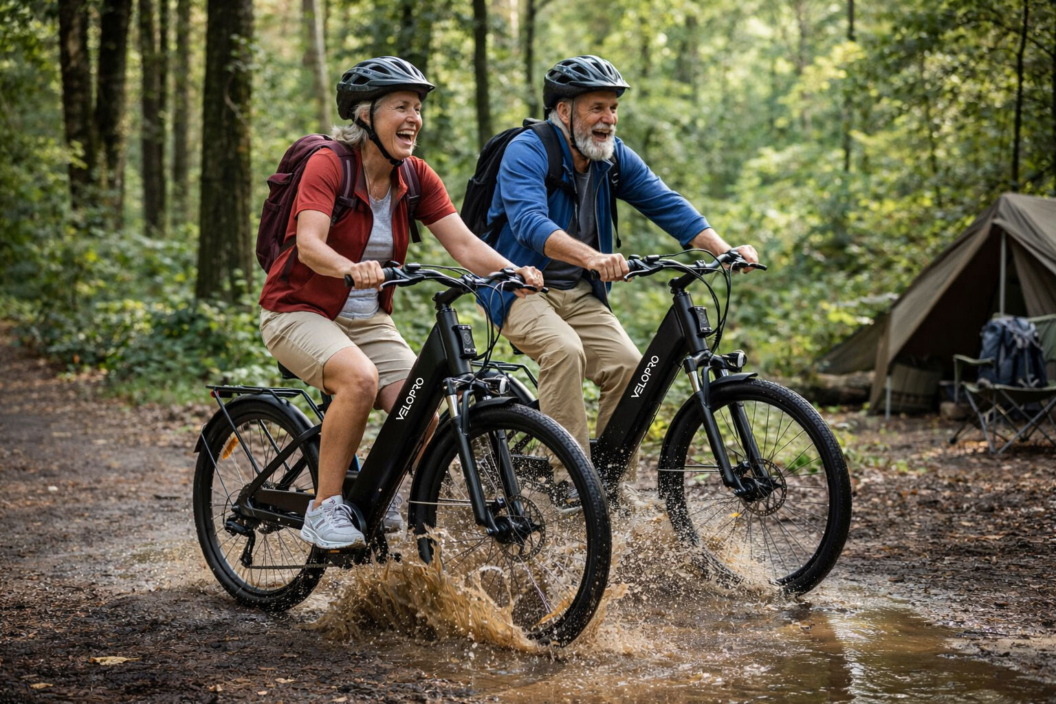 Älteres Paar fährt lächelnd mit E-Bikes durch Schlammwasser im Wald.
