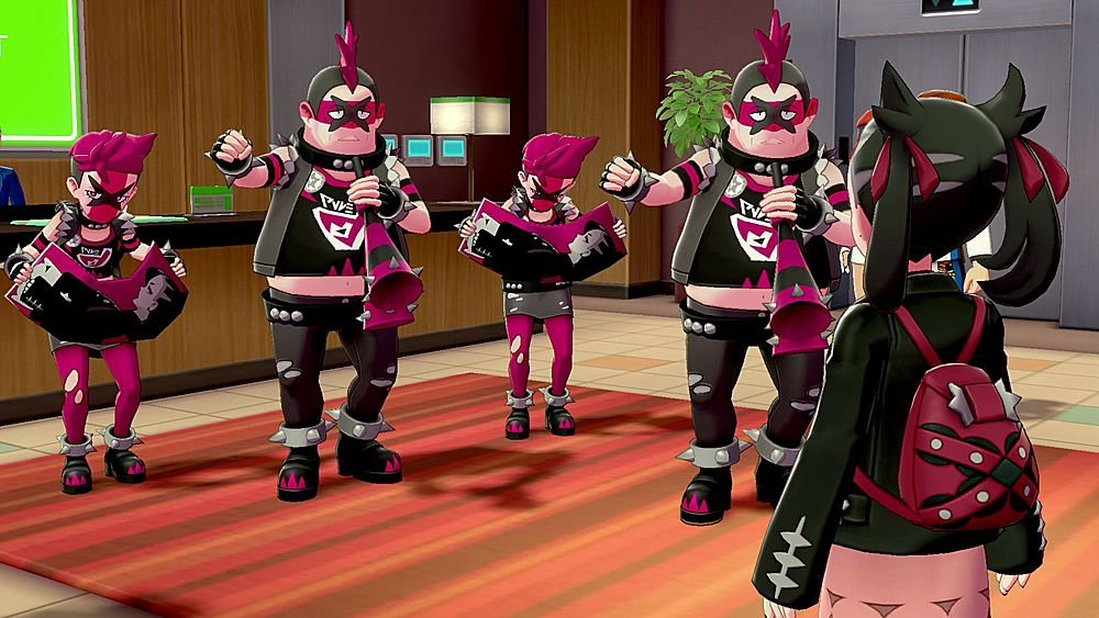 Quattro reclute del Team Yell con creste rosa suonano strumenti davanti a un giovane giocatore in un interno.