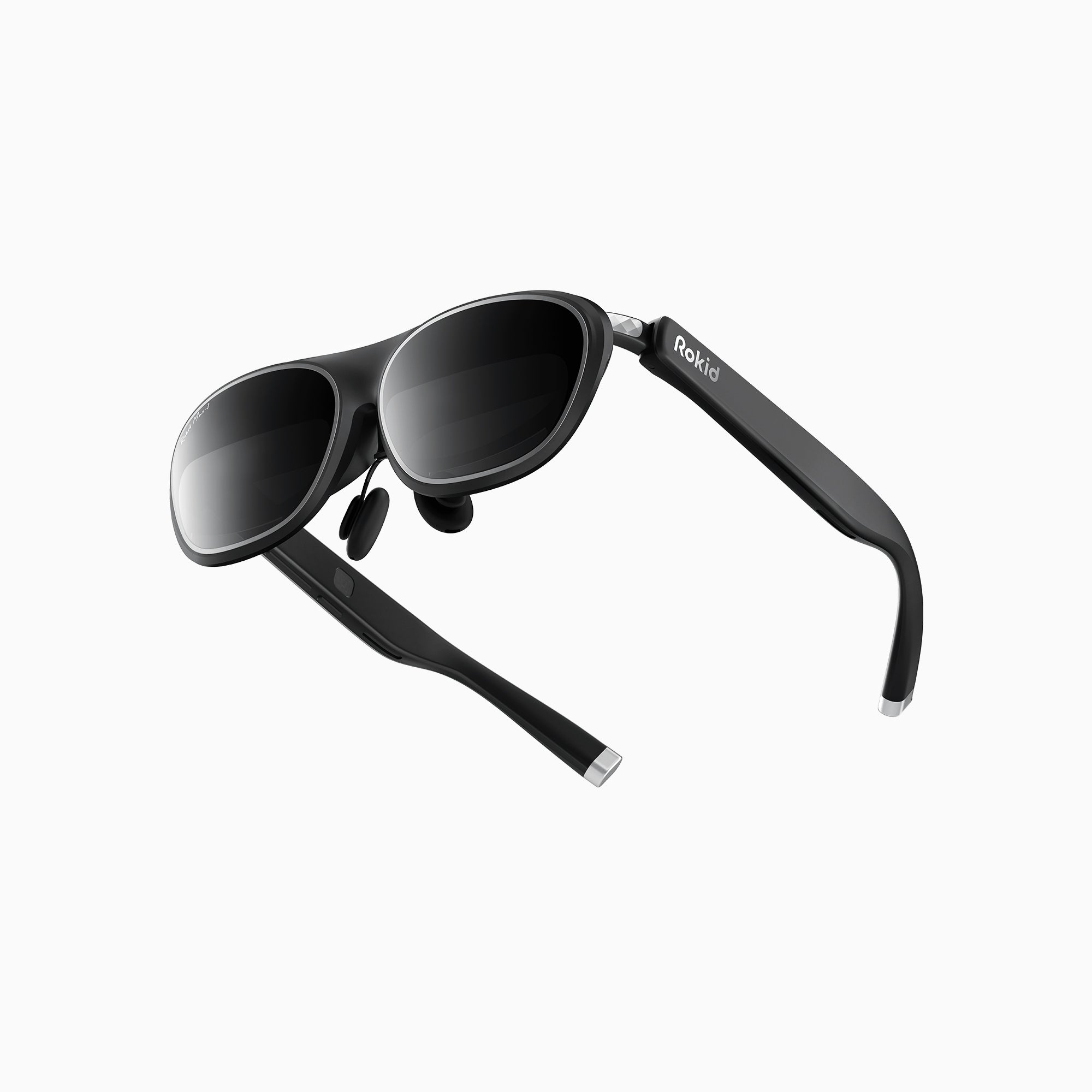 Eleganti occhiali smart neri con lenti scure e il marchio Rokid sull'asta, visti da una angolazione bassa.
