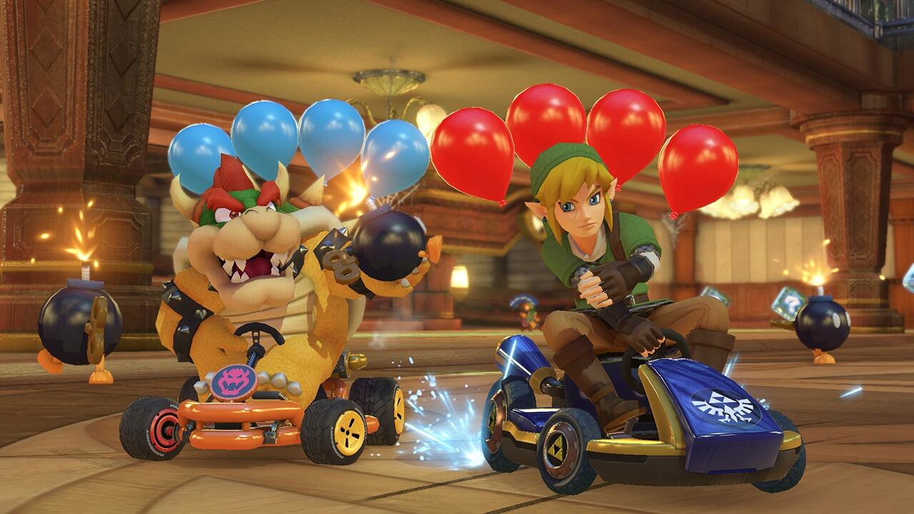 Bowser y Link corren en karts con globos en un gran salón.