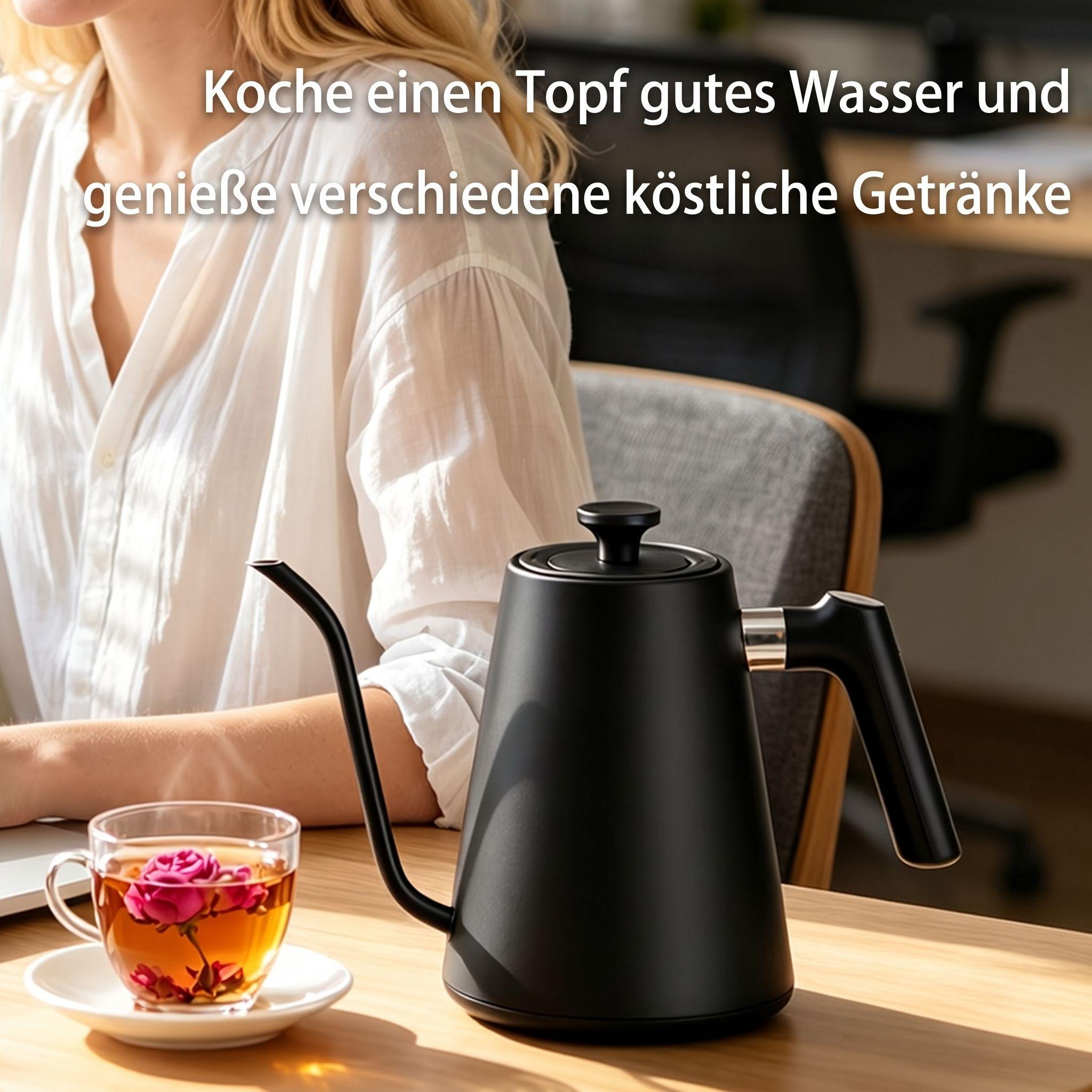 Ein schwarzer Schwanenhalskocher und eine Tasse Tee mit Blumen auf einem Holztisch, eine Frau sitzt im Hintergrund.