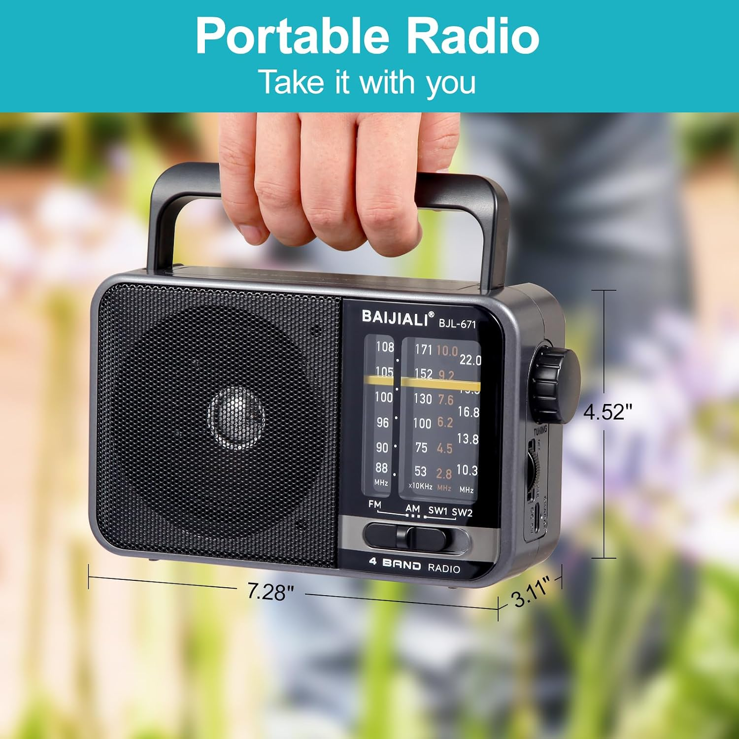Eine Hand hält ein graues tragbares Radio mit beschrifteten Maßen vor einem verschwommenen Hintergrund.