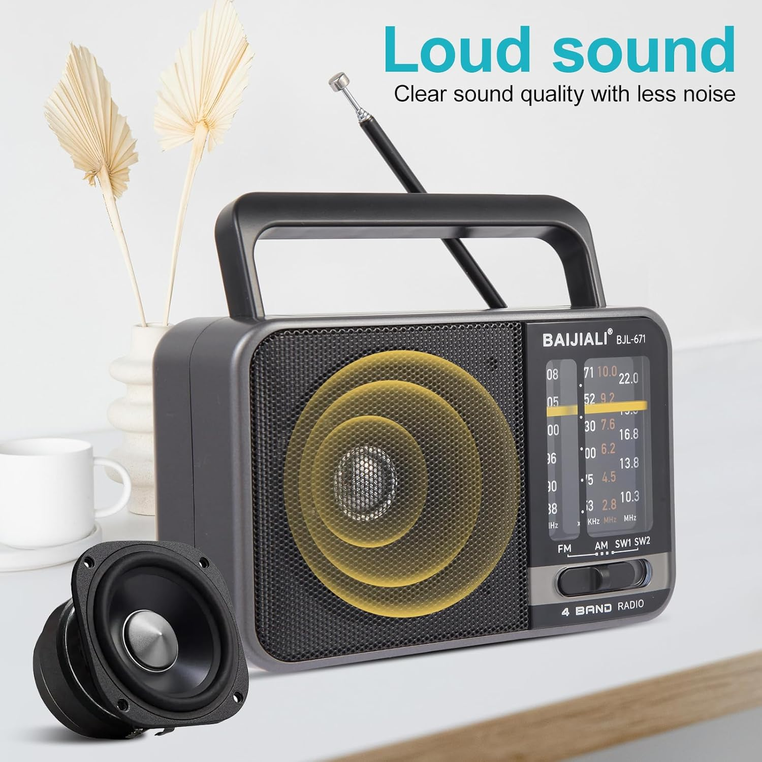 Ein graues 4-Band-Radio mit Antenne und einem separaten Lautsprecher auf einem Tisch.