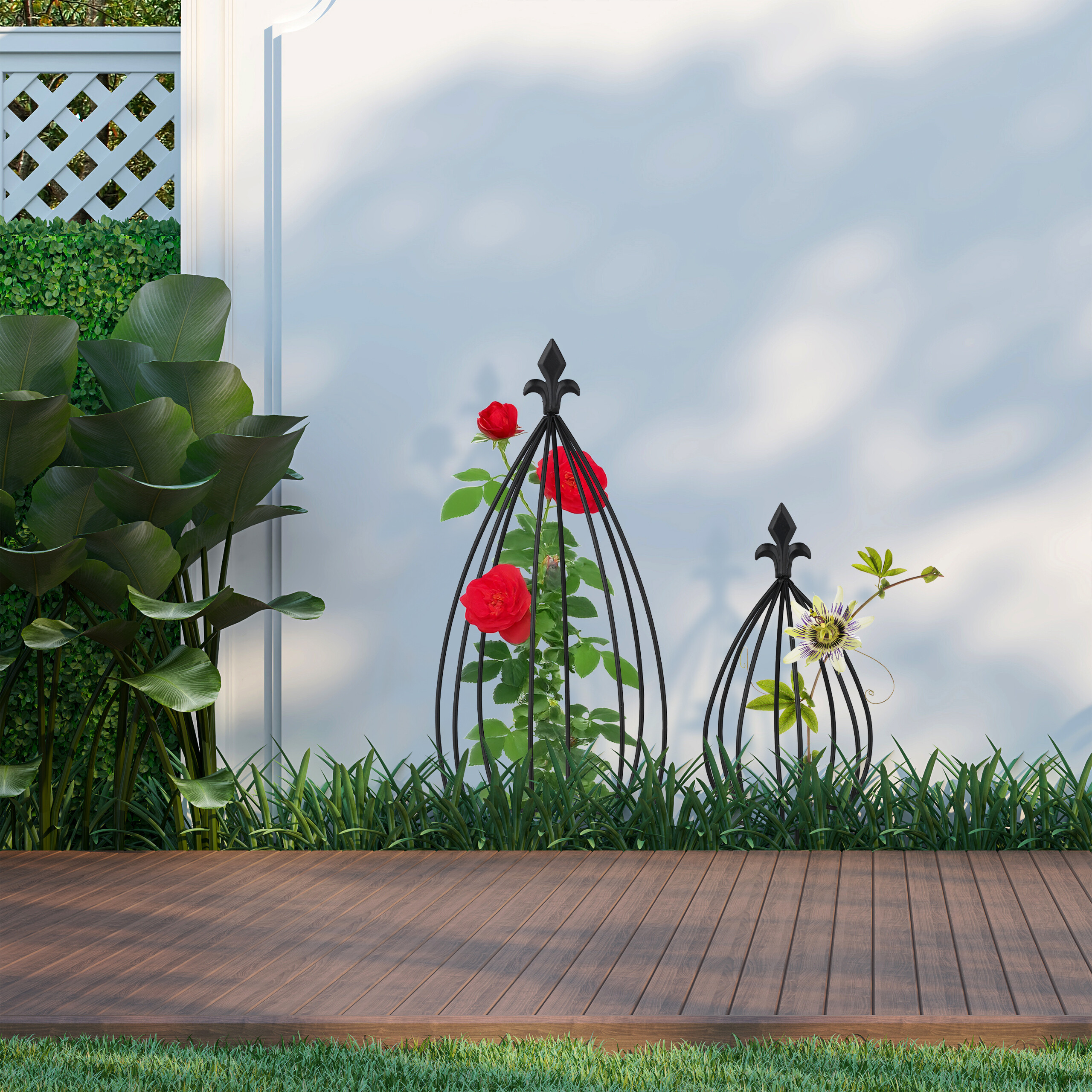 Zwei schwarze Metallobelisken auf einer Holzterrasse mit roten Rosen und einer Passionsblume vor einer weißen Wand.