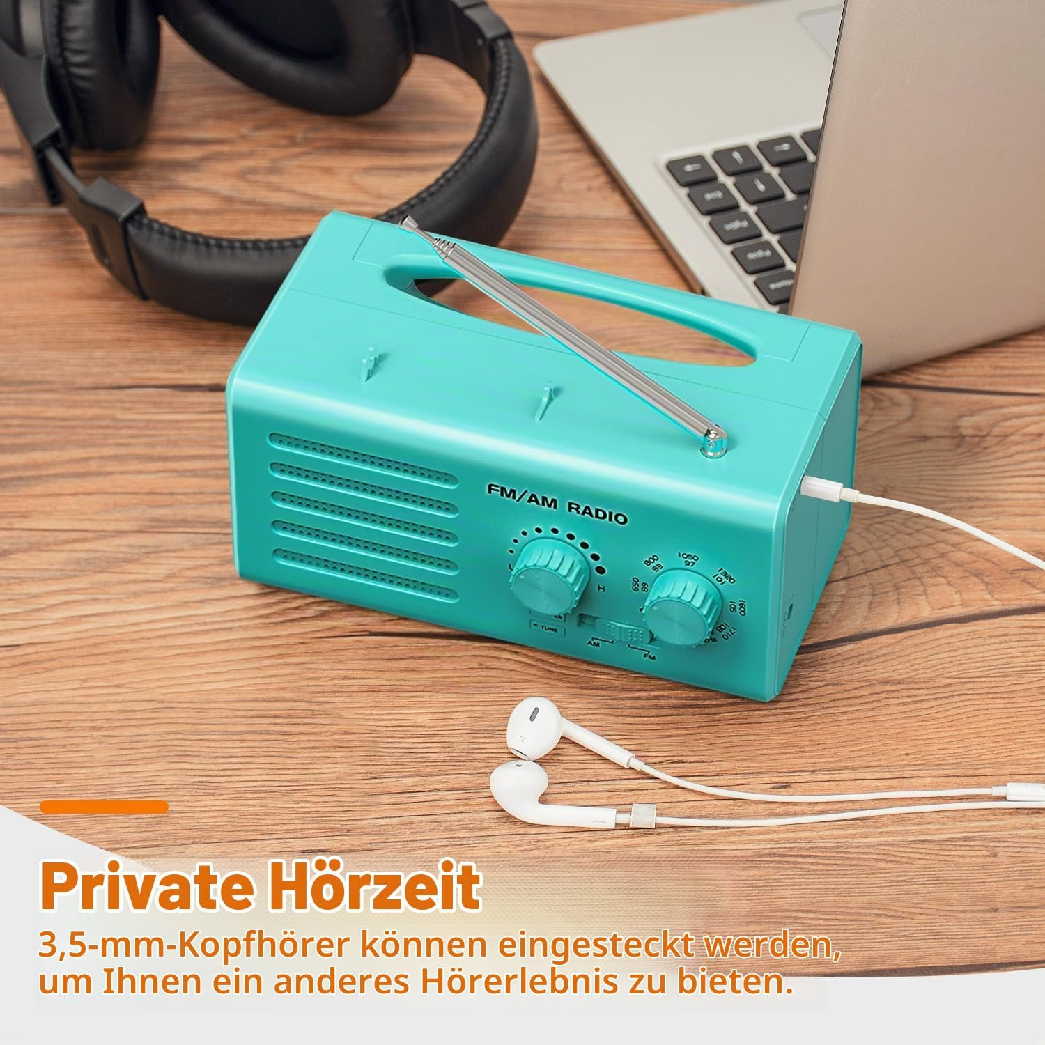 Ein türkisblaues UKW/MW-Radio mit Kopfhörern und einem Laptop auf einem Holztisch.